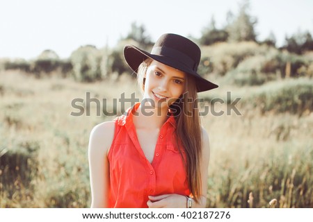Young girl doing emotion.Dressed in a black shirt, black sweater,black hat,glasses and bright lips,trendy clothes red jaket,outfit and hat,vacation style,bright colors.Sensual woman