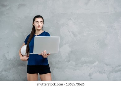 Young girl doing exercises with volleyball ball watching online tutorials on laptop. A sports coach leads an online lesson. Online workout concept. Vintage color filter - Powered by Shutterstock