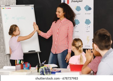 Young Girl Doing High Five With Her French Classes Teacher