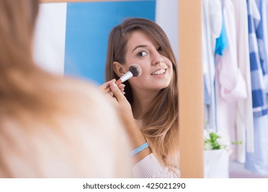 Young Girl Doing Makeup In Front Of Mirror.