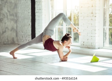 Young Girl Doing A Yoga Asana While Reading.