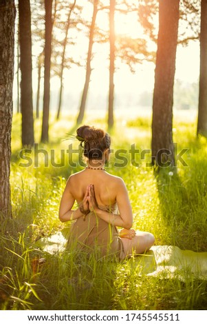 Young girl doing yoga fitness exercise outdoor. Morning sunrise, Namaste Lotus pose. Meditation and Relax