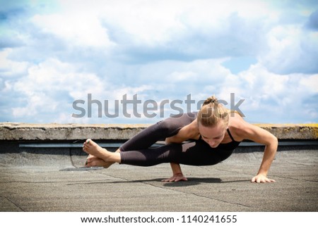 Young girl doing yoga on the roof of the building
