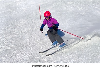 Young Girl Downhill Skiing On An Open Slope At A Ski Resort In Quebec, Canada