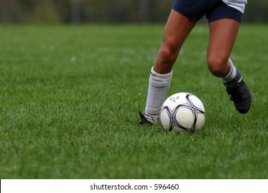 Young Girl Dribbling Soccer Ball.