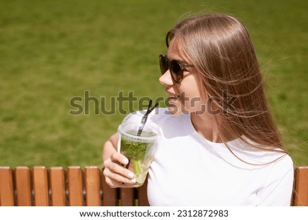 Similar – Frau mit Sonnenbrille, die im Freien grünen Gemüse-Smoothie trinkt.