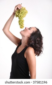 A Young Girl Eating A Big Bunch Of Grapes.