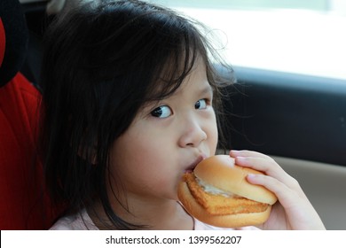 Young Girl Is Eating Hamburger Deliciously For Lunch In A Car 