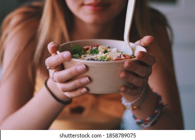 Young girl is eating healthy take out food