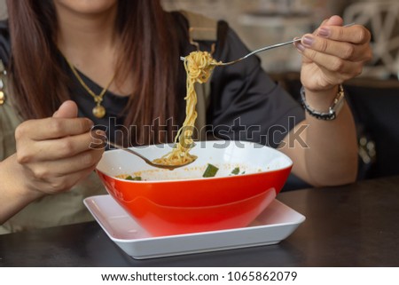 Young girl eating noodles,Hastily lunch,Tom Yum Noodles