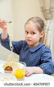 A Young Girl Is Eating A Spagetti With Patties