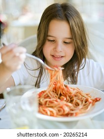 Young Girl Eating Spaghetti In Restaurant