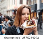 Young girl eating waffle with chocolate