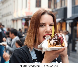 Young girl eating waffle with chocolate