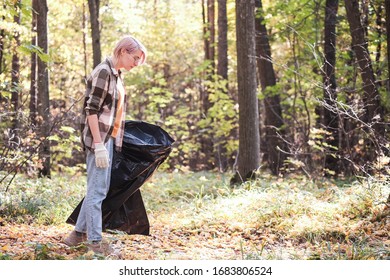 A Young Girl - An Eco Activist Collects Trash And Plastic In A Park And Forest Stacks Up In A Black Big Bag. Clean Eco System Concept