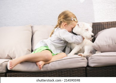 Young Girl Embracing Her Dog On Couch