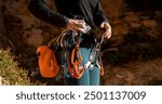 A young girl is engaged in active sports, rock climbing and mountaineering. A woman looks at a beautiful red rock and takes magnesia in her hand, getting ready for training and climbing.