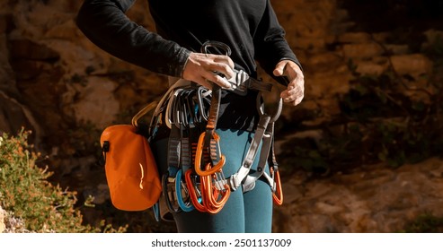 A young girl is engaged in active sports, rock climbing and mountaineering. A woman looks at a beautiful red rock and takes magnesia in her hand, getting ready for training and climbing. - Powered by Shutterstock