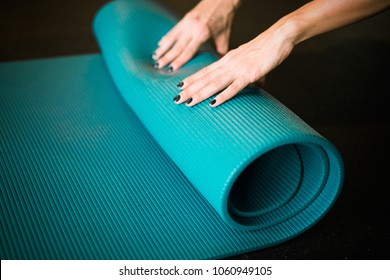 Young Girl Enrolling Blue Yoga Mat After Practicing Workout And Crossfit. Practicing Sport At Home Indoors. Stay Home. Quarantine. Self Isolation