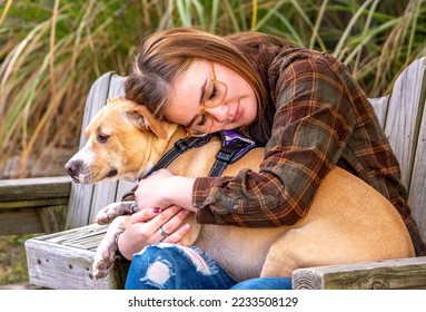 A young girl with epilepsy hugs her seizure alert dog, a very special companion - Shutterstock ID 2233508129