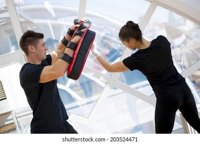 Young girl exercise punching with her coach - Powered by Shutterstock