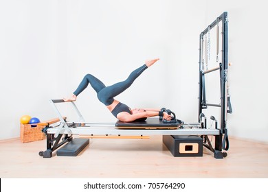 Young girl exercising on pilates reformers beds