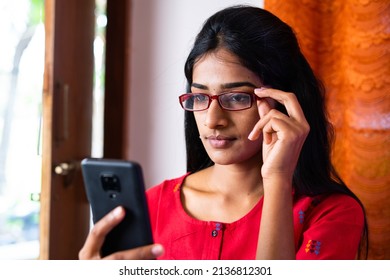 Young Girl With Eye Glasses Busy Using Mobile Phone At Home - Concept Of Social Media, Internet And Eyesight Problem