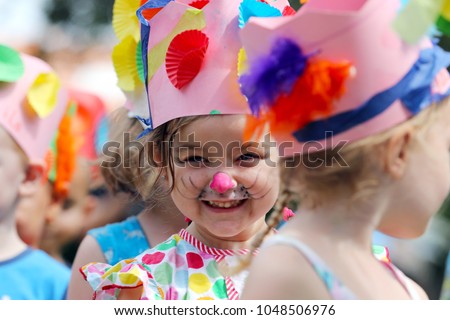 Young girl with face painted as a rabbit in the Easter hat parade at her kindergarten. 