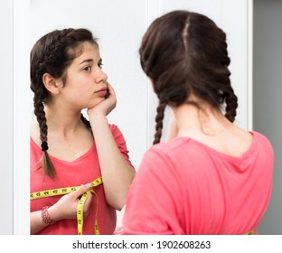 Young girl feeling unhappy with breast size gain at home - Shutterstock ID 1902608263