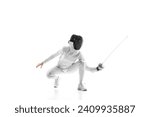 Young girl, fencer, sportsman squats with sword, dodging opponent during fight against white studio background. Caution and attentiveness in sports. Concept of active lifestyle, fitness, strength.