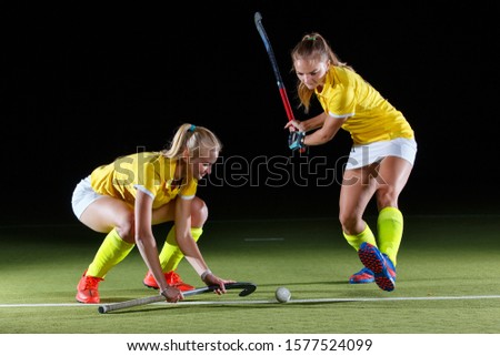 Young girl field hockey player hit the ball in penalty stroke.