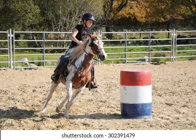 Young girl galloping around a barrel during a barrel race