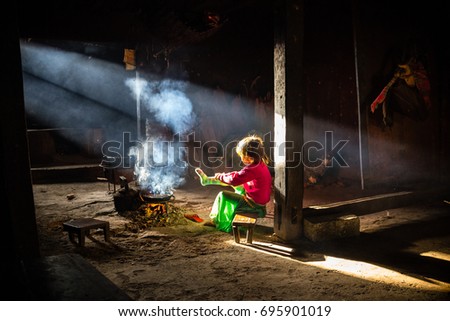 Young girl gets ready for school in Farmer's hut in Vietnam in Ha Giang province.