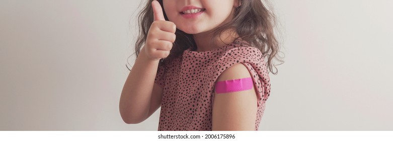 Young  Girl Giving Thumb Up And Showing Her Arm With Pink Bandage After Got Vaccinated Or Inoculation, Child Under 12 Years Old Immunization, Health Concept