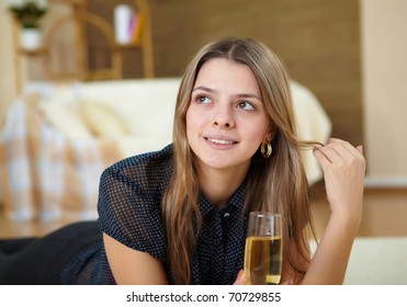 a young girl with a glass of wine or champagne at home on the carpet - Shutterstock ID 70729855