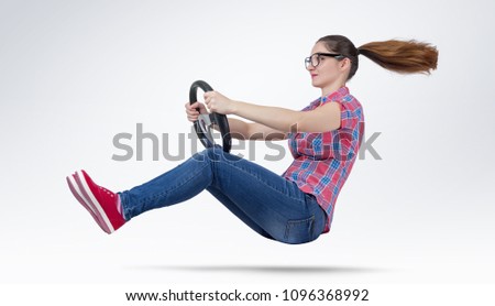 Young girl in glasses driver car with a wheel