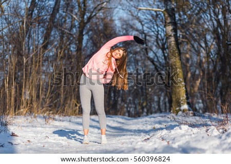 Young girl goes in for sports in winter park. Tilt are one of the general developmental exercises.