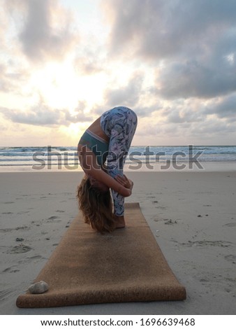 Young girl gorilla yoga pose at seaside at sunset