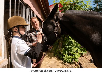 A young girl grooming a horse with guidance from an instructor. Routine on a farm, caring for animals in the countryside - Powered by Shutterstock