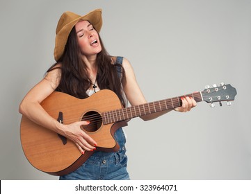 young girl guitar play. Gray background. Country style.