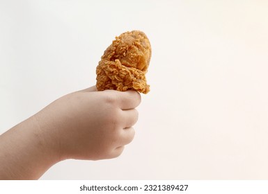 Young girl hand holding chicken drumstick isolated on white background - Powered by Shutterstock