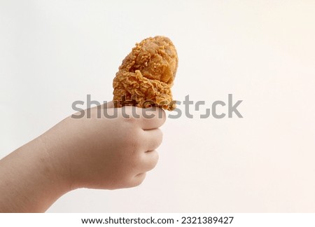 Young girl hand holding chicken drumstick isolated on white background