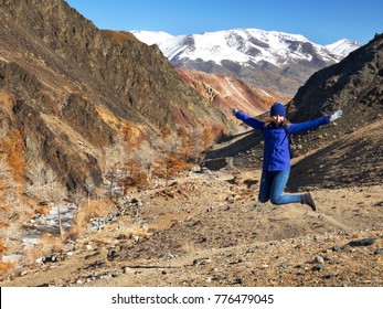 The young girl happy jump in mountains with exciting view. Autumn mountain landscape.