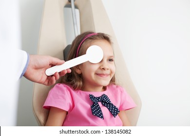 Young Girl Is Having Eye Exam Performed By Optician, Optometrist Or Eye Doctor.