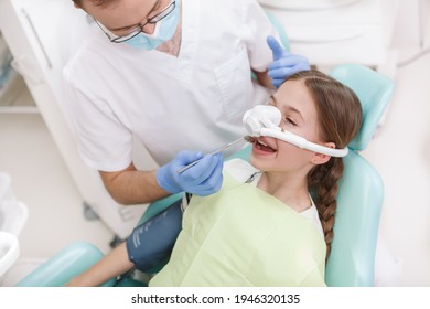 Young girl having her teeth treated while having inhalation sedation mask on - Shutterstock ID 1946320135