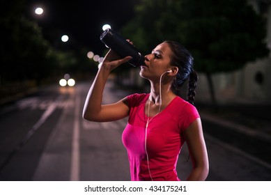 Young girl having a refreshment after a night running session. High ISO - Powered by Shutterstock