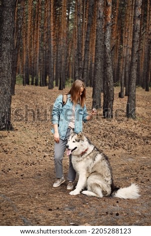 Young Girl with her Dog, Alaskan Malamute, Outdoor at Autumn. Domestic pet
