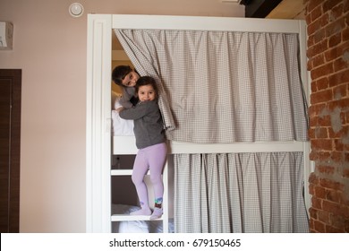 Young Girl And Her Sister About To Go To Sleep On Bunk Bed