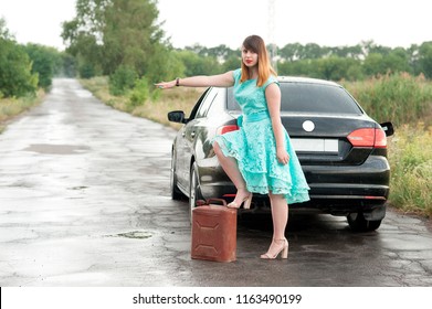 A Young Girl Hitchhiking. Girl And Empty Tank. Girl And Technical Assistance On The Road. A Girl With An Empty Gas Can