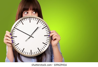 A Young Girl Holding A Clock On Green Background